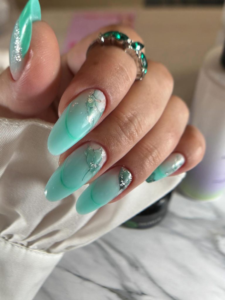 Uñas almendradas en tono menta con decoración